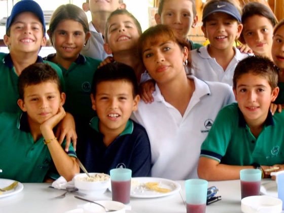 FRP-about-us-inline A group of children drinking soda standing and sitting next to a counselor.